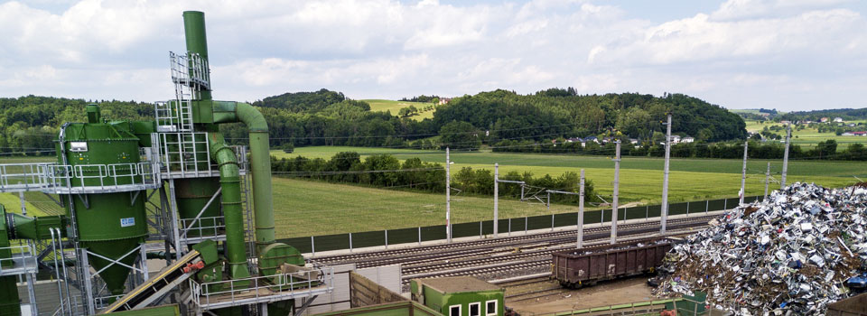 Anlage der Müller-Guttenbrunn Gruppe in Amstetten mit eigenem Gleisanschluss, Schrottlager und Mostviertler Landschaft im Hintergrund
